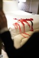 A bed with a red rope tied to it.