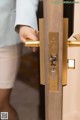 A person opening a door with a brass door handle.