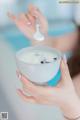 A woman holding a bowl of yogurt with a spoon in it.