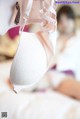 A woman in a wedding dress is putting on a bra.