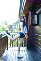 A woman standing on a wooden deck with her legs in the air.