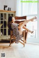 A woman sitting in a rocking chair with her legs up.