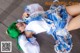 A woman with green hair laying on a wooden floor.