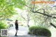 A woman standing on a path next to a body of water.