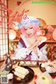 A woman with pink hair sitting at a table with food.