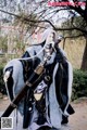 A mannequin dressed in a black and white outfit holding a sword.