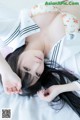 A woman laying on top of a bed in a sailor outfit.