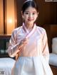 A young girl wearing a pink and white hanbok.