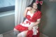 A woman in a red and white dress sitting on a window sill.