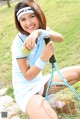 A woman holding a tennis racket and a tennis ball.