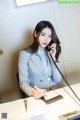 A woman sitting at a desk talking on a phone.