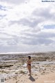 A woman in a bikini standing on a beach.