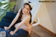 A woman sitting on a bean bag chair wearing a cat ears headband.