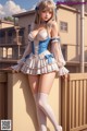 A woman in a blue and white dress posing on a balcony.