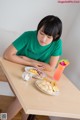 A woman sitting at a table with a plate of food.