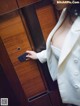 A woman in a white suit holding a credit card.