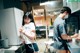 A man and a woman standing in a kitchen next to a refrigerator.