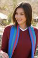 A young woman wearing a red sweater and a colorful scarf.