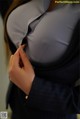 A woman in a business suit adjusting her shirt.