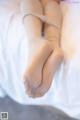 A close up of a person laying on a bed with their feet up.