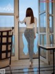 A woman standing in front of a glass door.