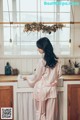 A woman standing in a kitchen next to a sink.