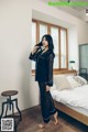 A woman standing in front of a bed in a bedroom.