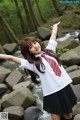 A woman in a school uniform is posing for a picture.