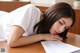 A woman laying on top of a table next to a piece of paper.